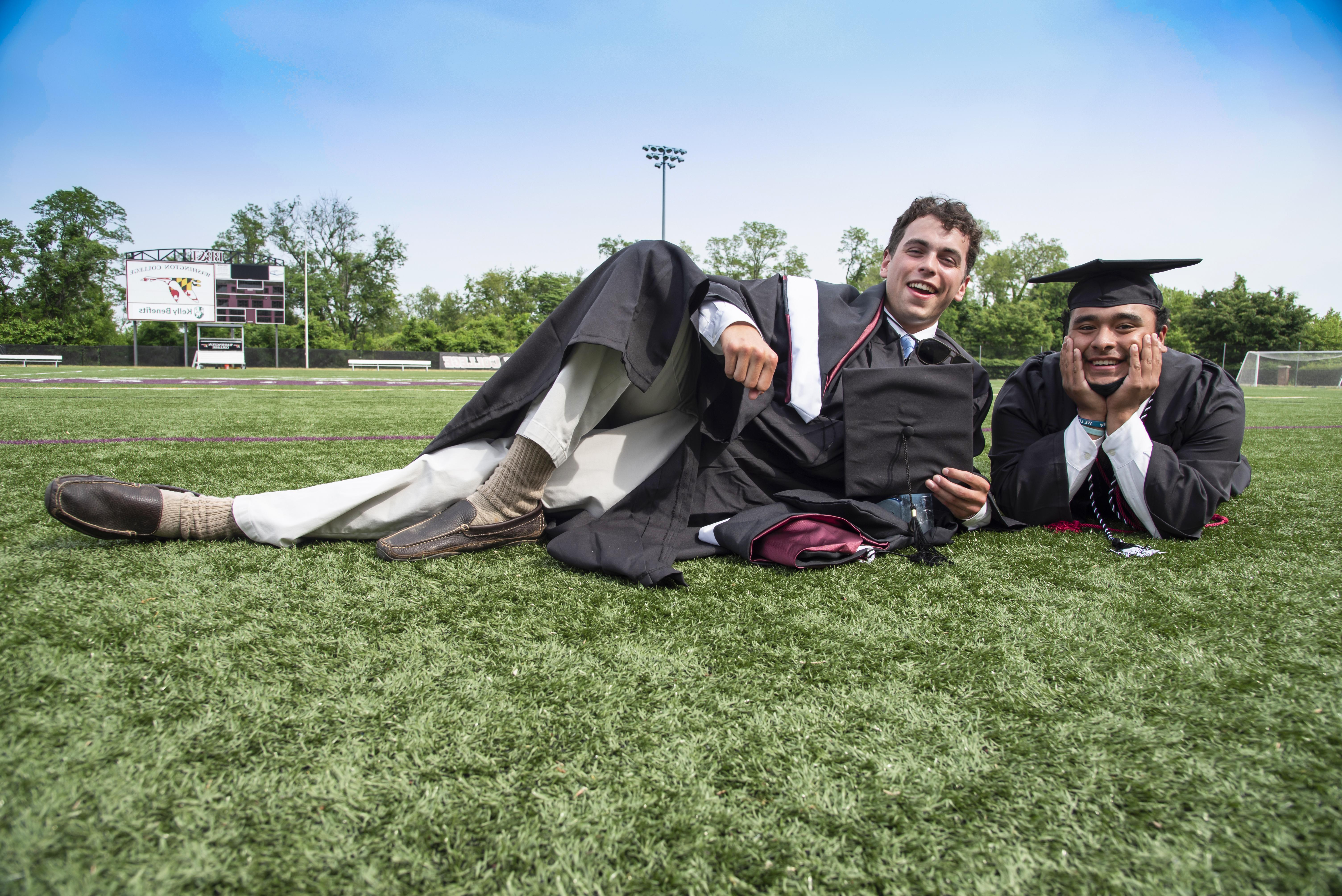 graduates laying on lawn